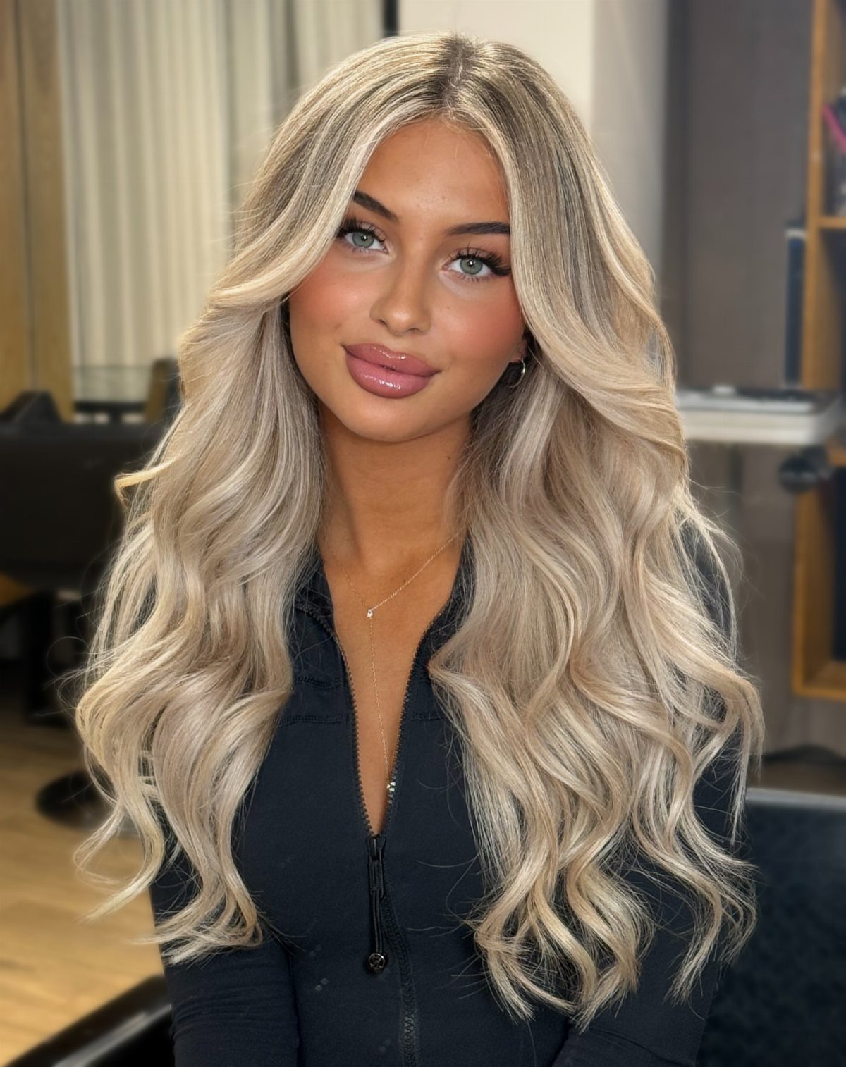 Long wavy blonde hair with beige roots and bright platinum balayage strands