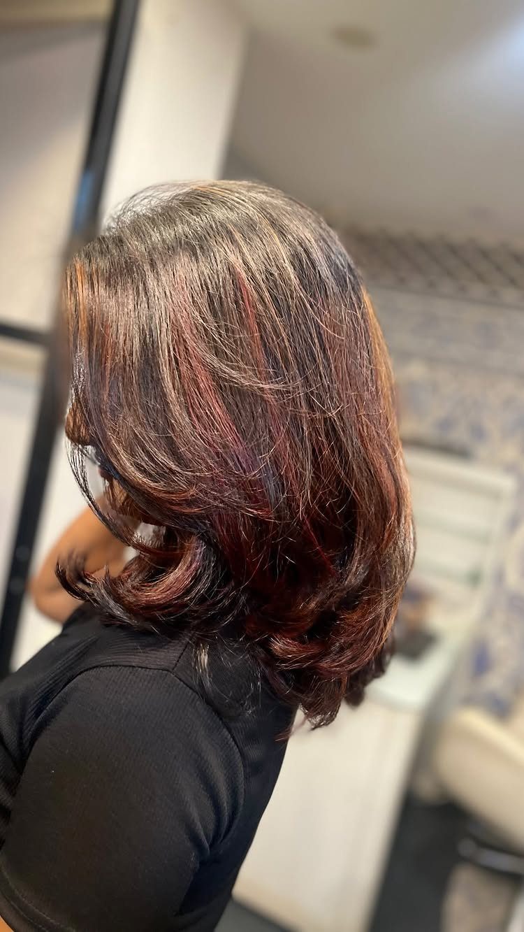 Layered dark brown bob with subtle reddish highlights and loose curls