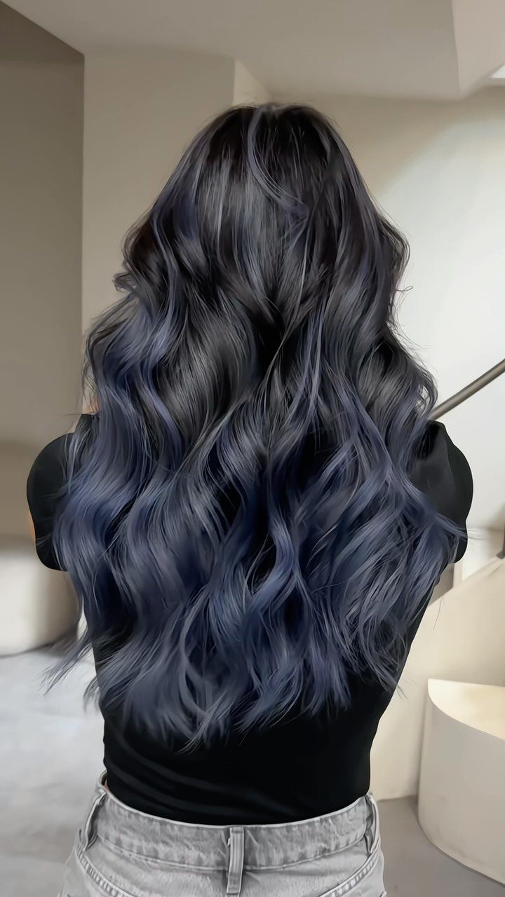 Long wavy black hair with subtle blue balayage tones through the lengths