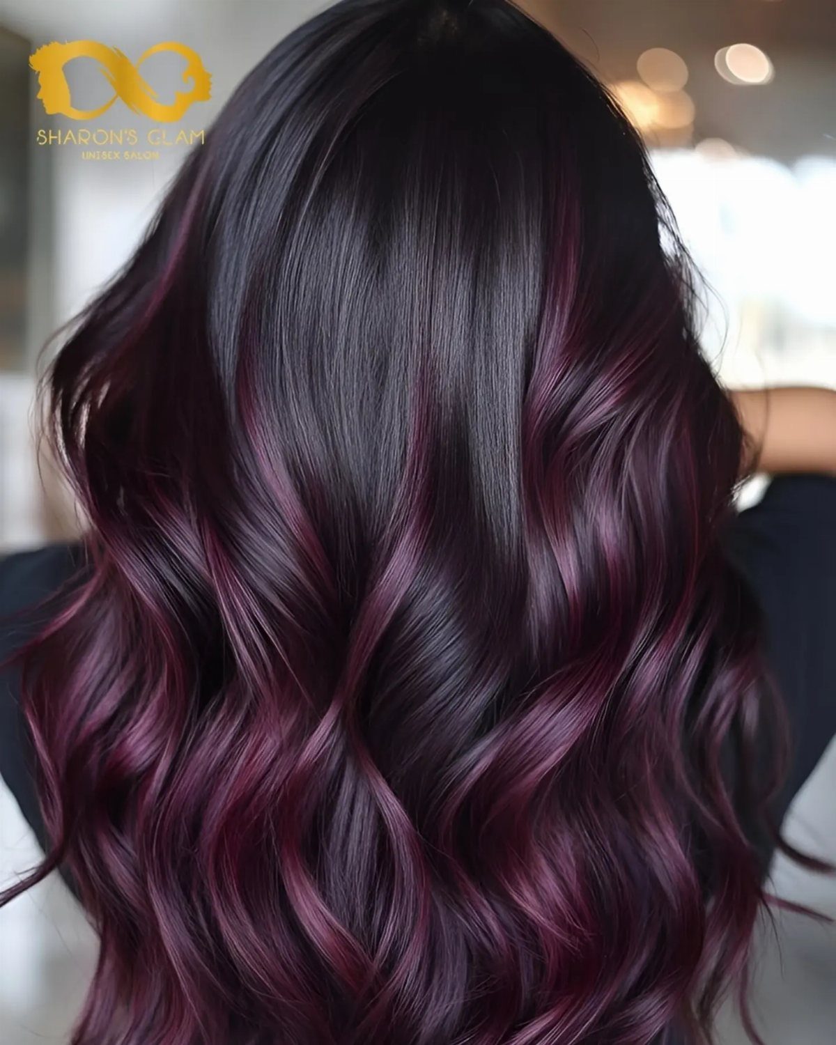 Near-black wavy hair with subtle burgundy highlights through the lengths