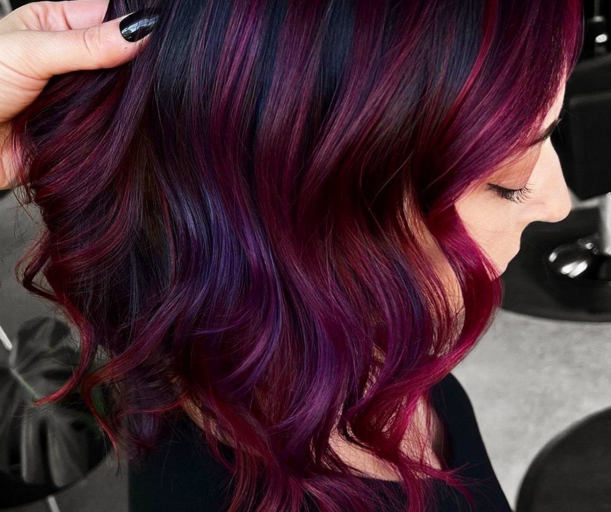Dark curled hair with glossy burgundy and cherry-red rosewood highlights