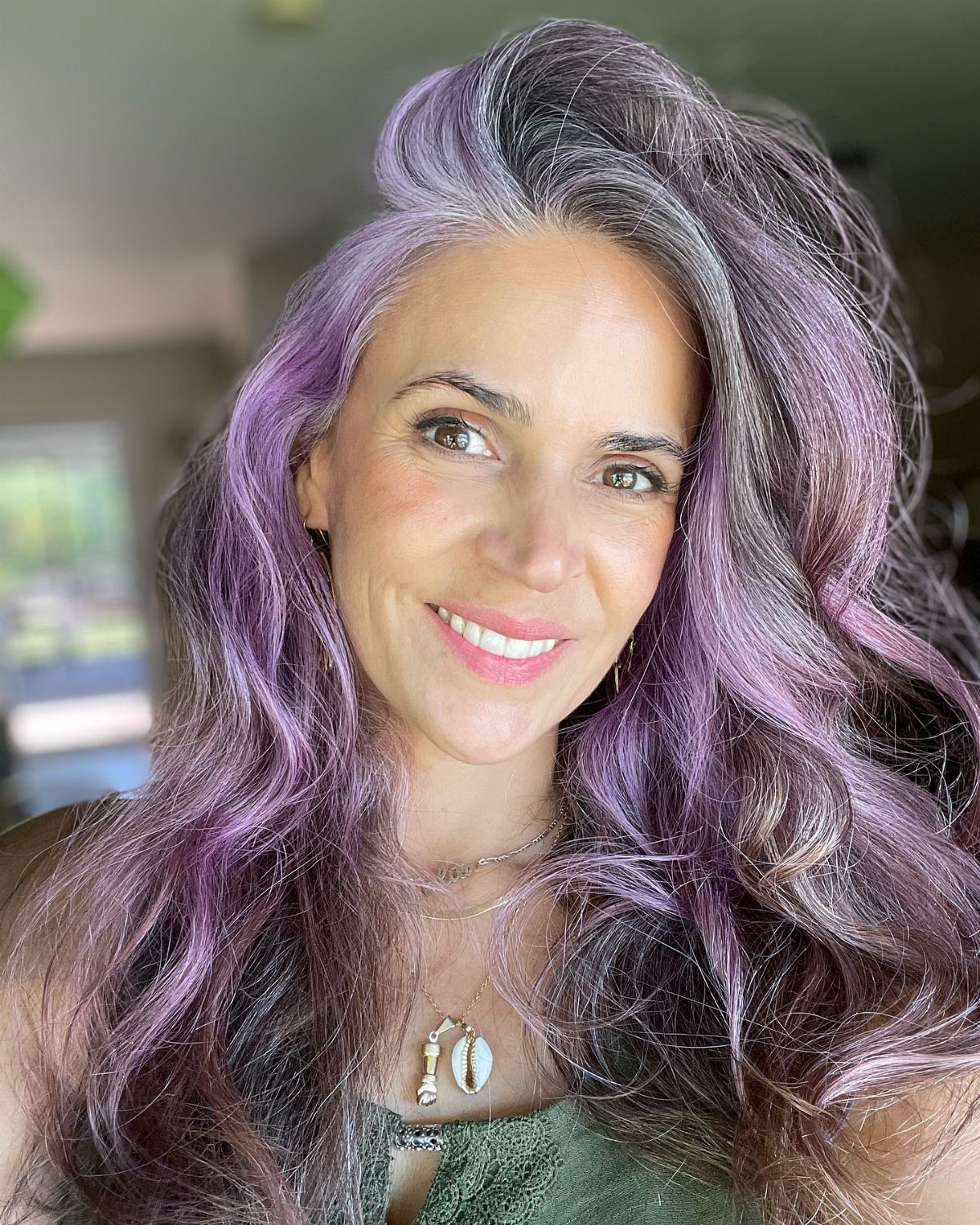 Woman with long charcoal hair interspersed with soft lavender waves
