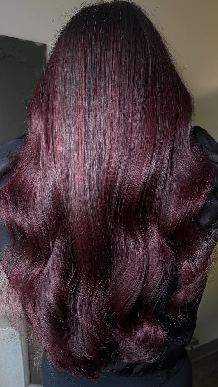 Long wavy hair blends dark brown with glossy cherry-burgundy tones