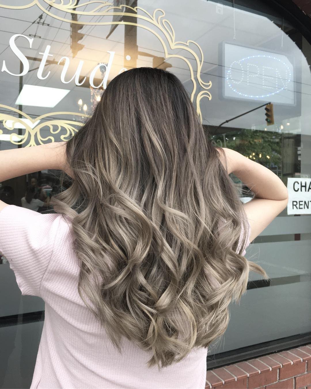 Long ash-brown highlighted waves transition from dark roots to lighter ends