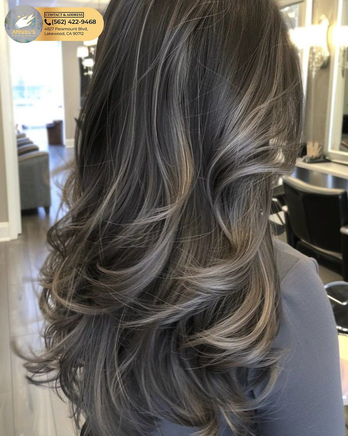 Long layered hair blends dark roots into smoky ash-gray and pale highlights