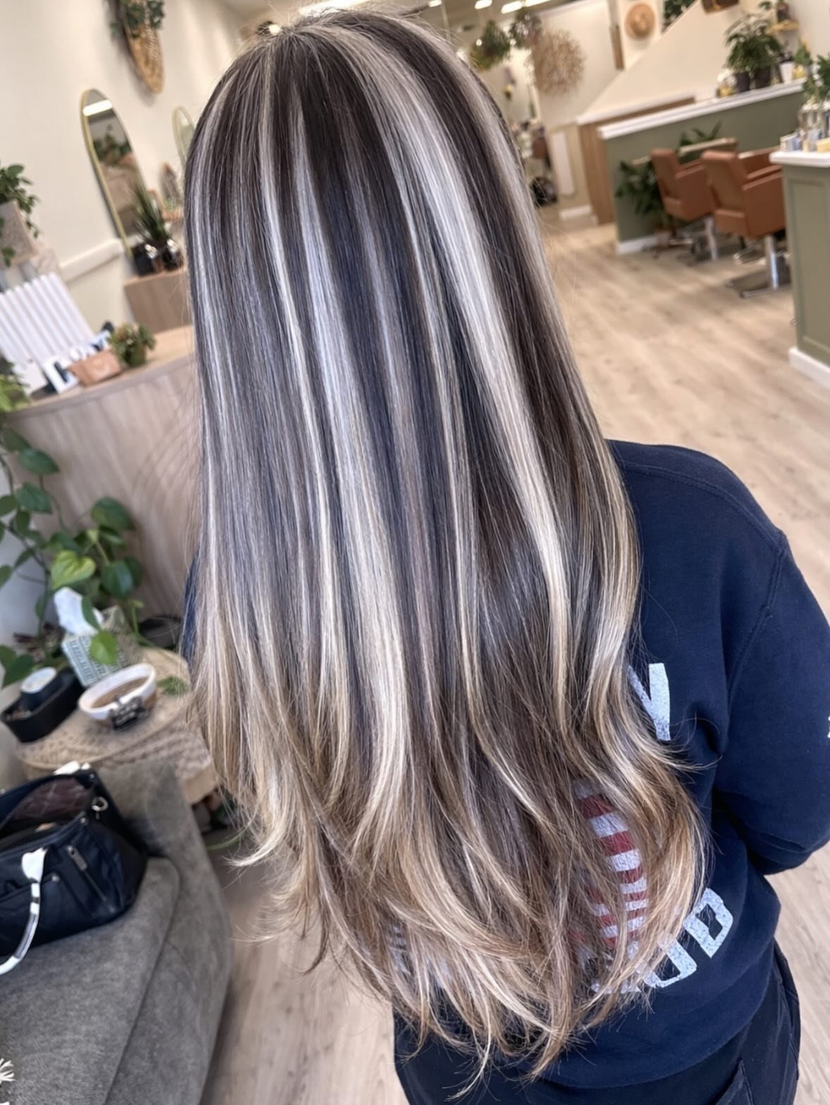 Long dark-rooted hair with bold silver-platinum blonde balayage streaks