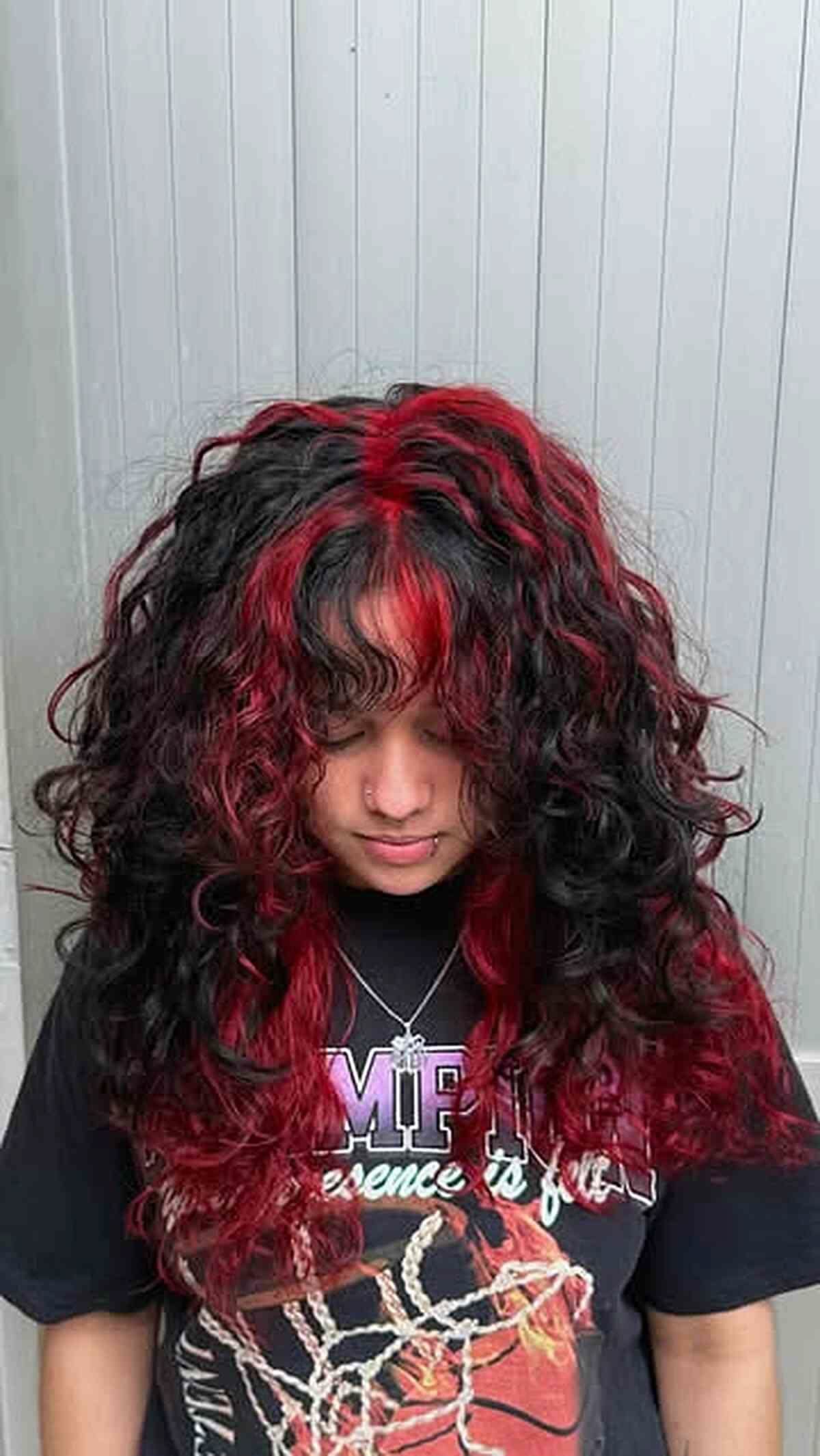 Person displaying long black curls with scattered burgundy-red highlights against a paneled wall