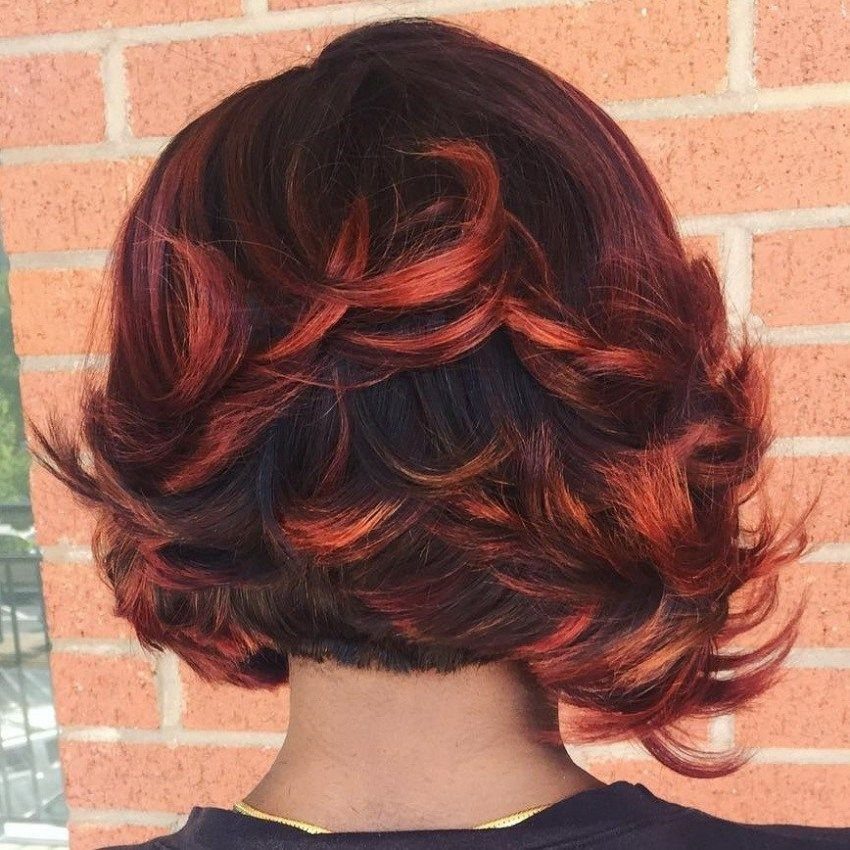 Short wavy dark bob with vivid red highlights curling through the ends