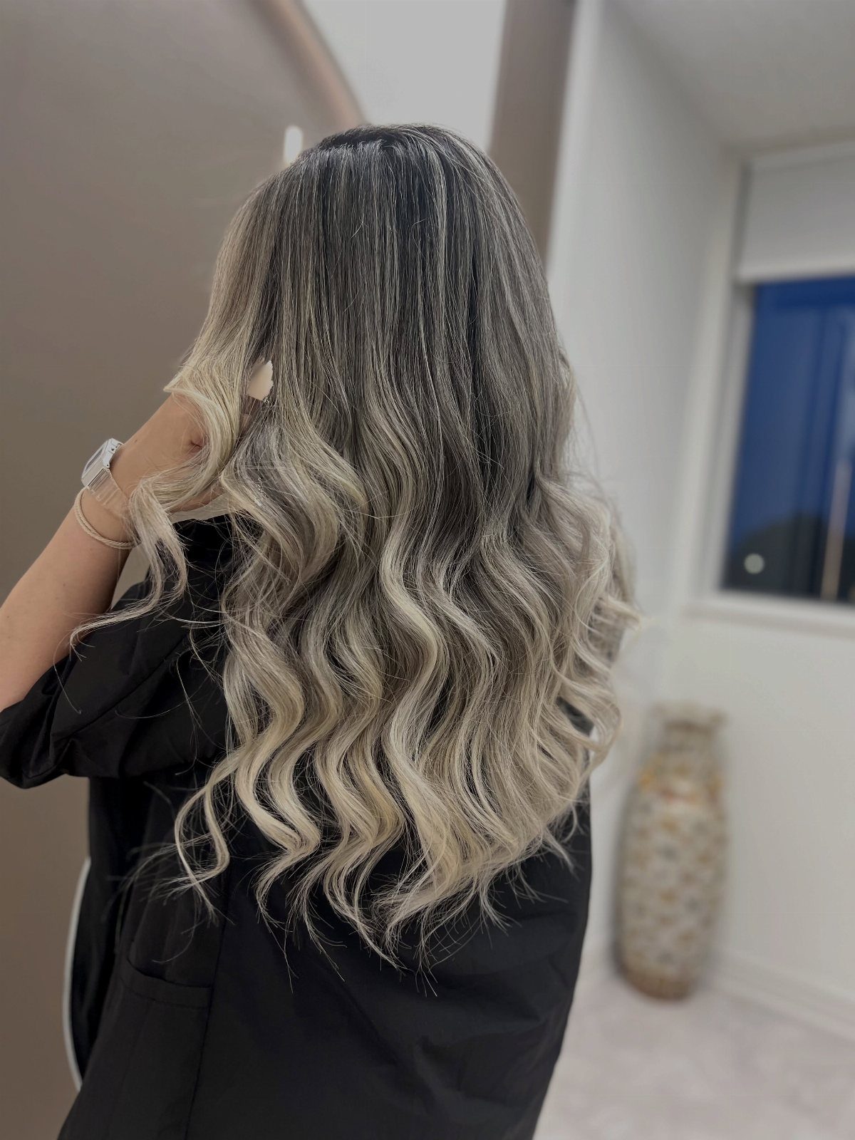 Long dark waves blend into ash-platinum balayage highlights