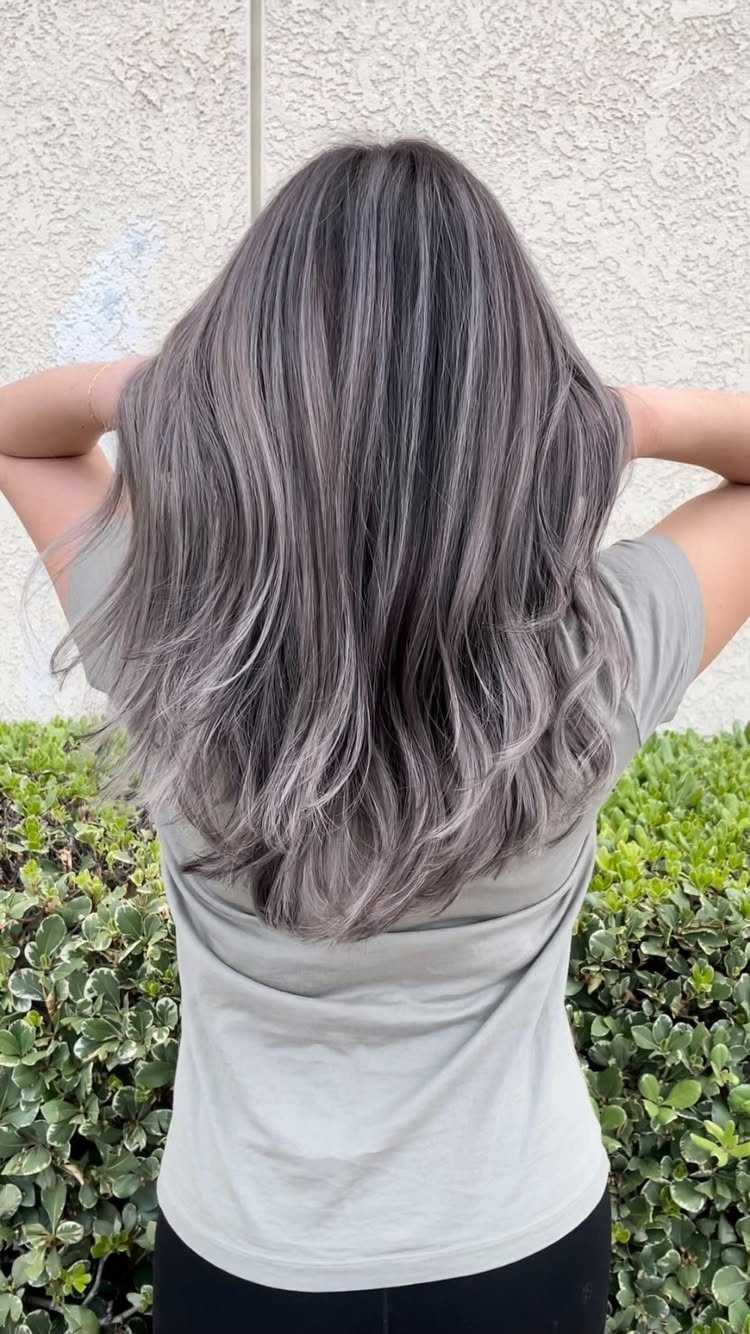 Long wavy dark hair blended with cool gray and silver balayage