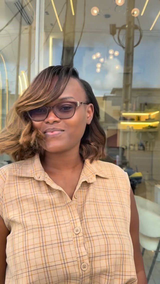 Woman with caramel highlights wears her textured short bob in loose curls
