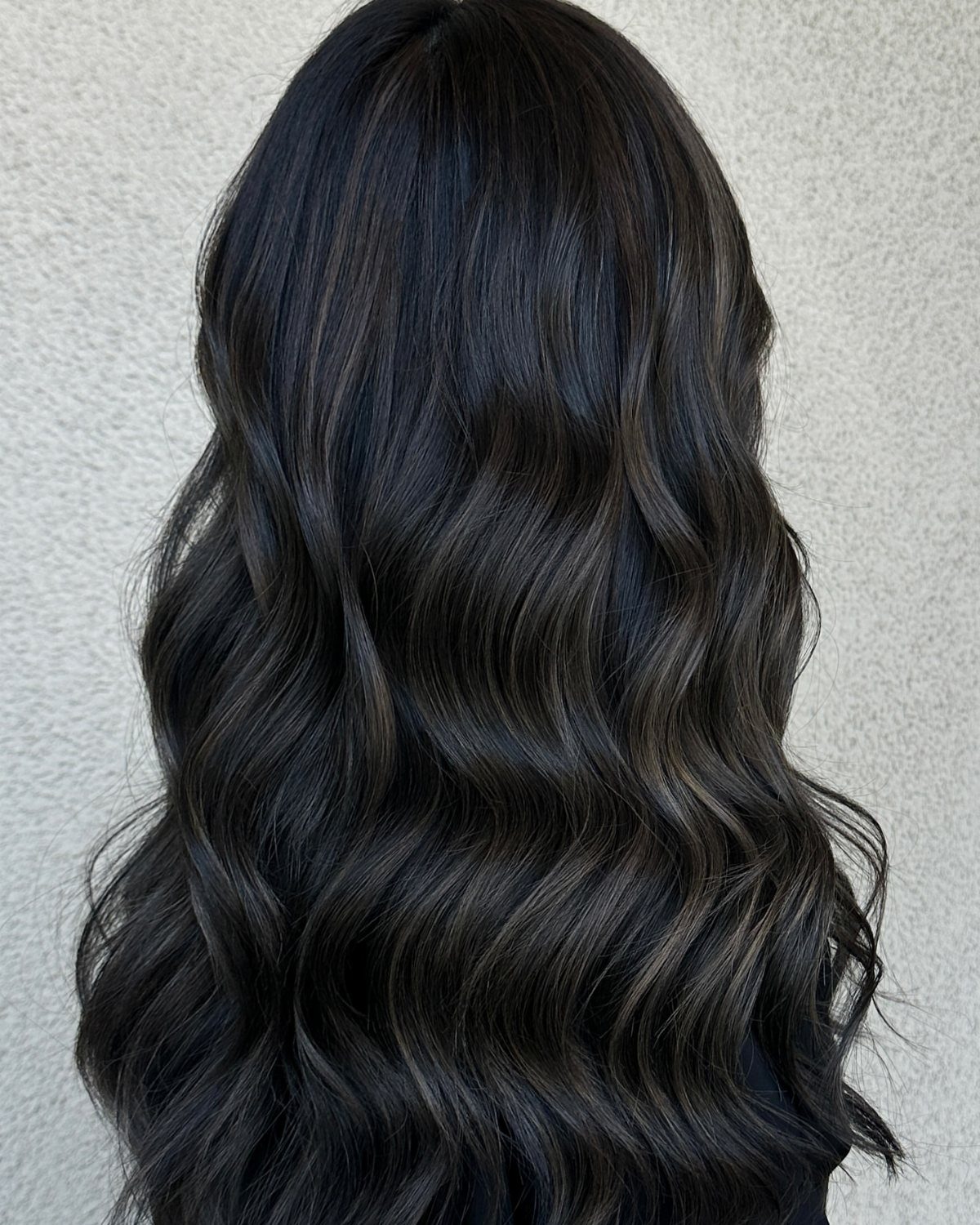 Long blue-black waves show subtle, fine cool-brown highlights