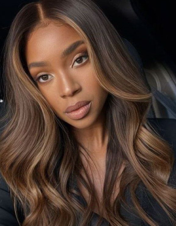Long dark waves show warm chestnut highlights framing the woman's face.