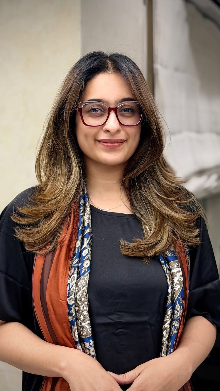 Woman with long dark hair and warm golden brown highlights