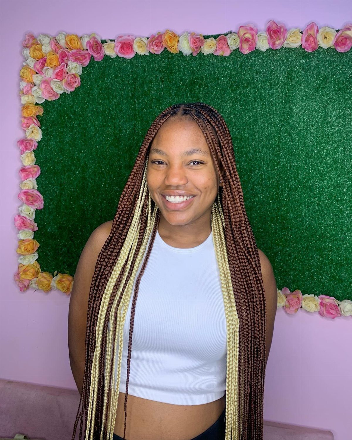 Woman displaying long two-tone box braids with dark brown and blonde strands