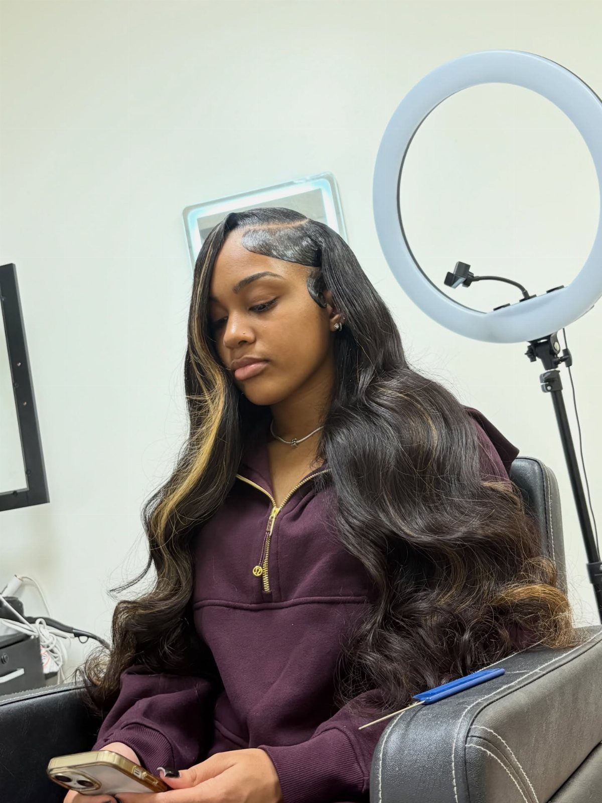 Woman displaying long dark hair with subtle brown ribbons and a side part
