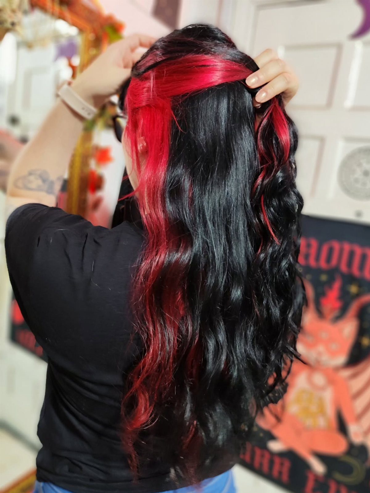 Long black hair lifted to reveal vivid crimson underlights