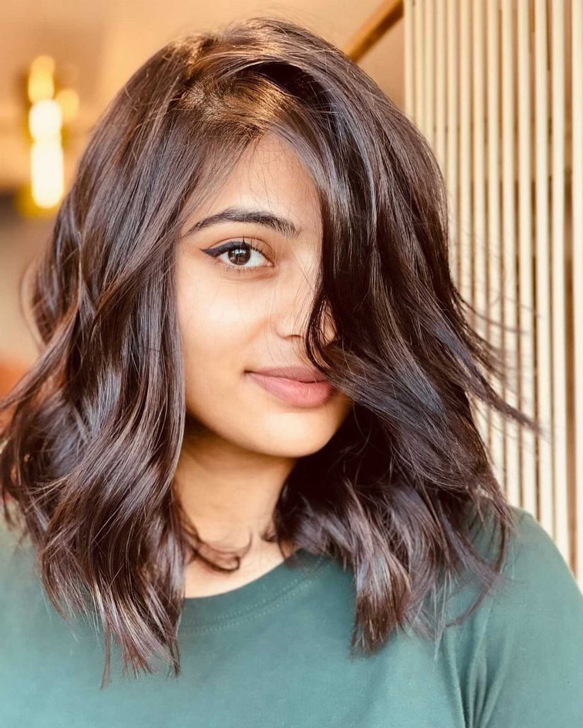 Woman showing a wavy dark lob with subtle warm brown highlights