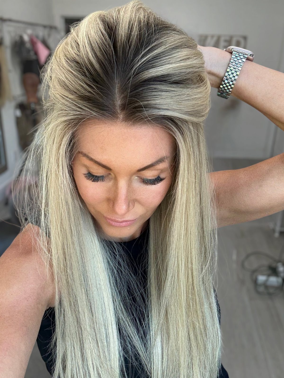Long blonde hair with darker roots is lifted to reveal its smooth color transition