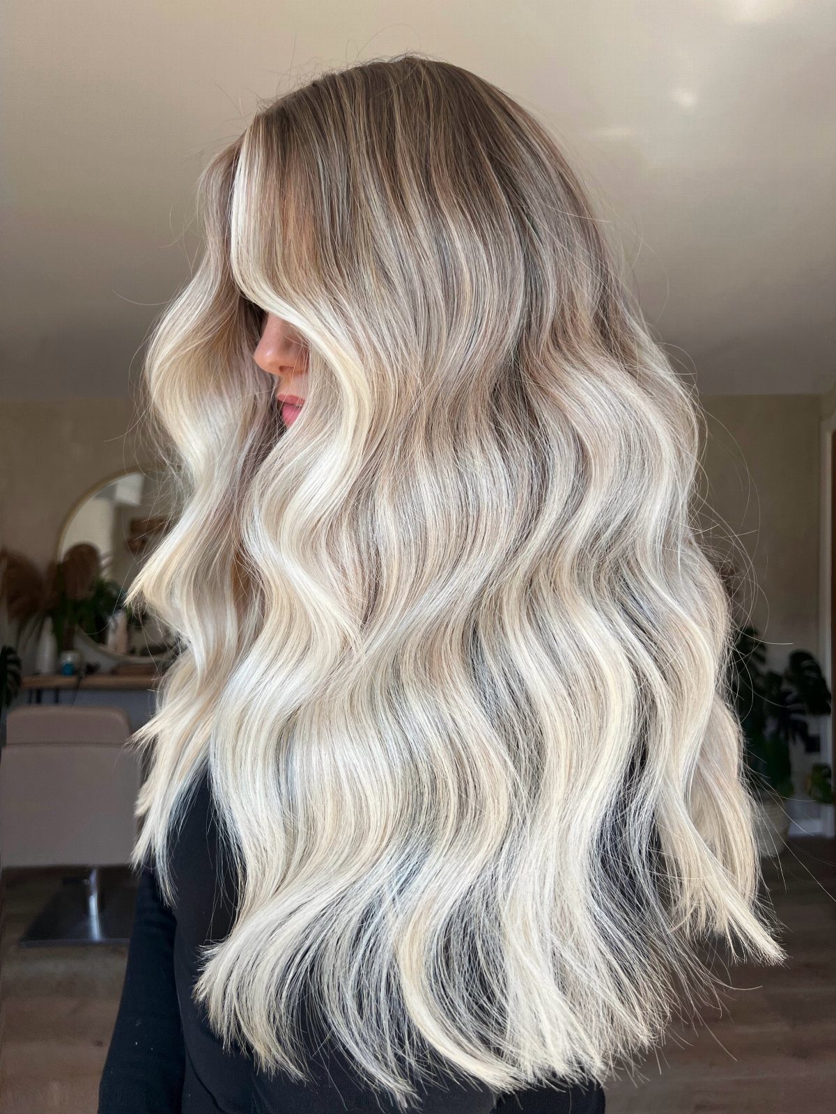 Long wavy blonde hair with darker roots and contrasting light strands