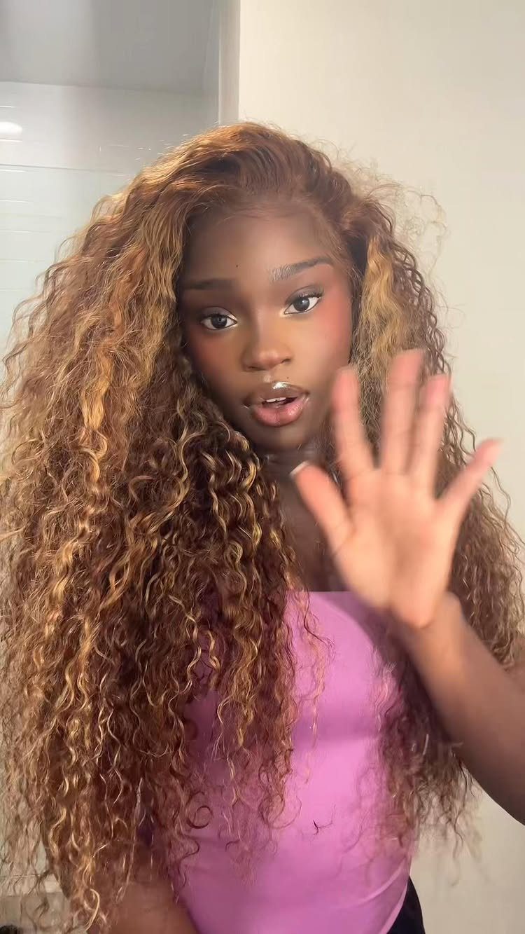 Woman with long natural curls showing warm caramel honey highlights