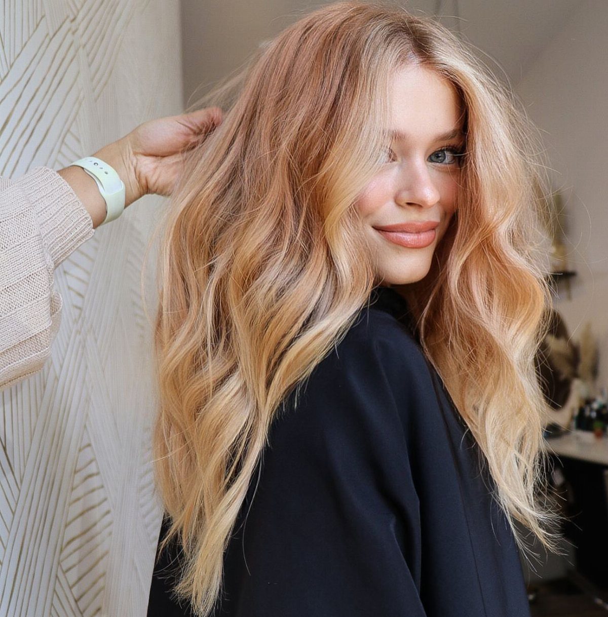 Woman with long wavy strawberry-blonde hair and warm golden tones