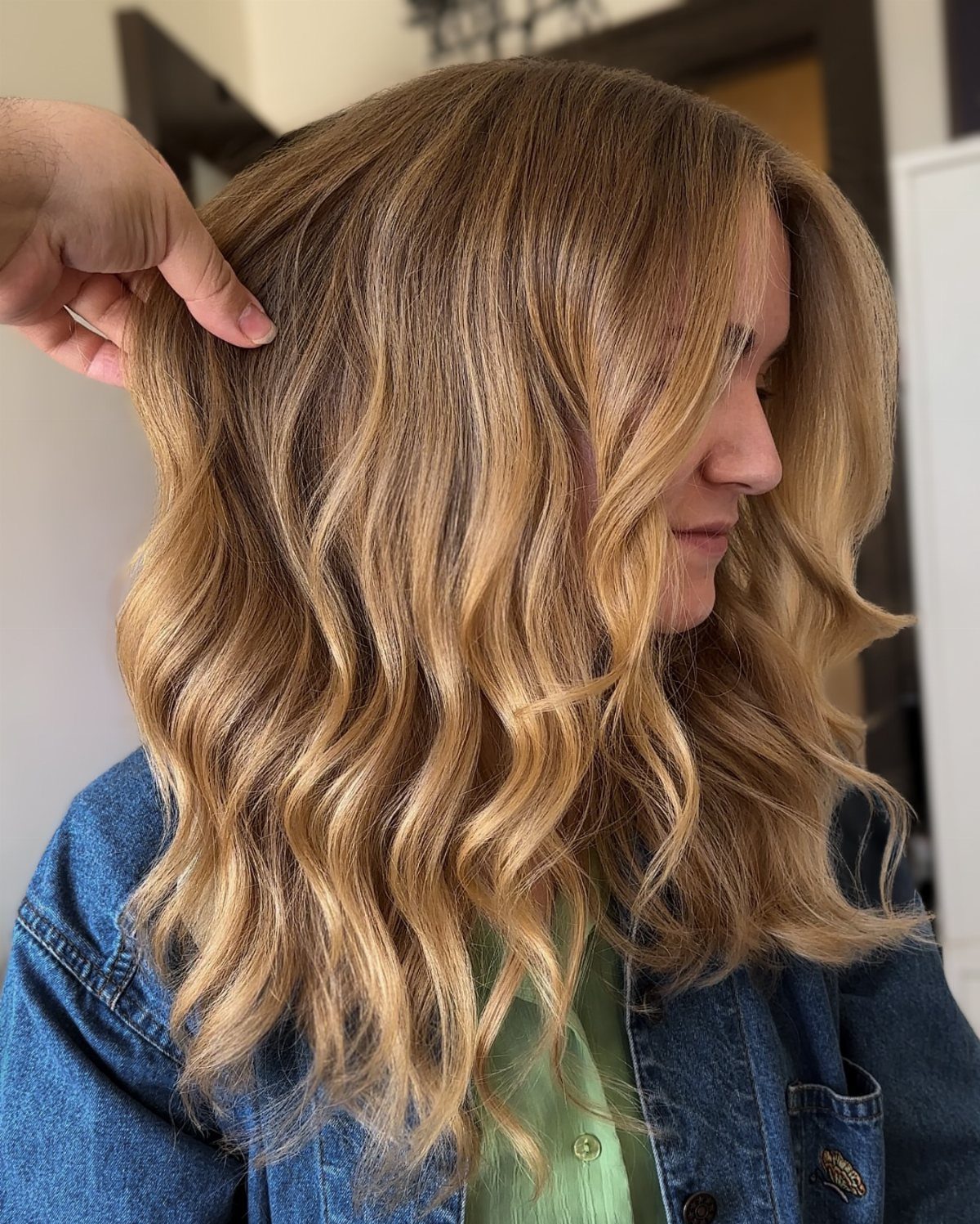 Wavy light brown hair with subtle golden honey highlights around the face and crown