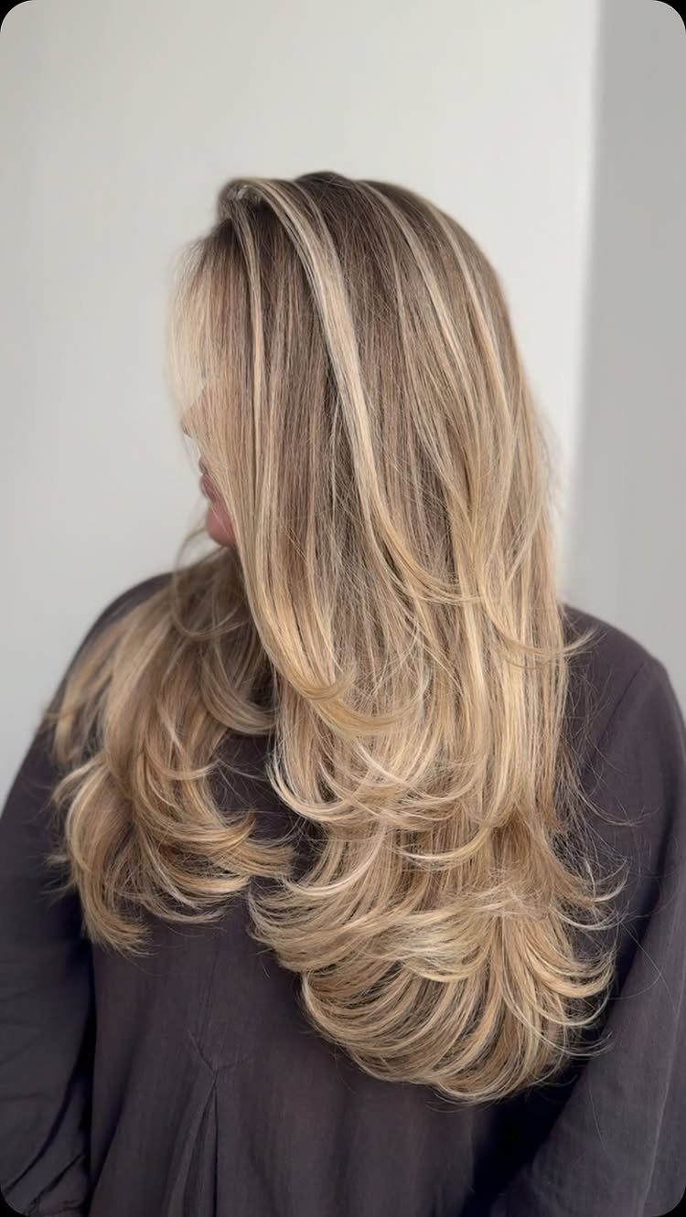 Layered blonde hair with beige balayage highlights and darker brown lowlights