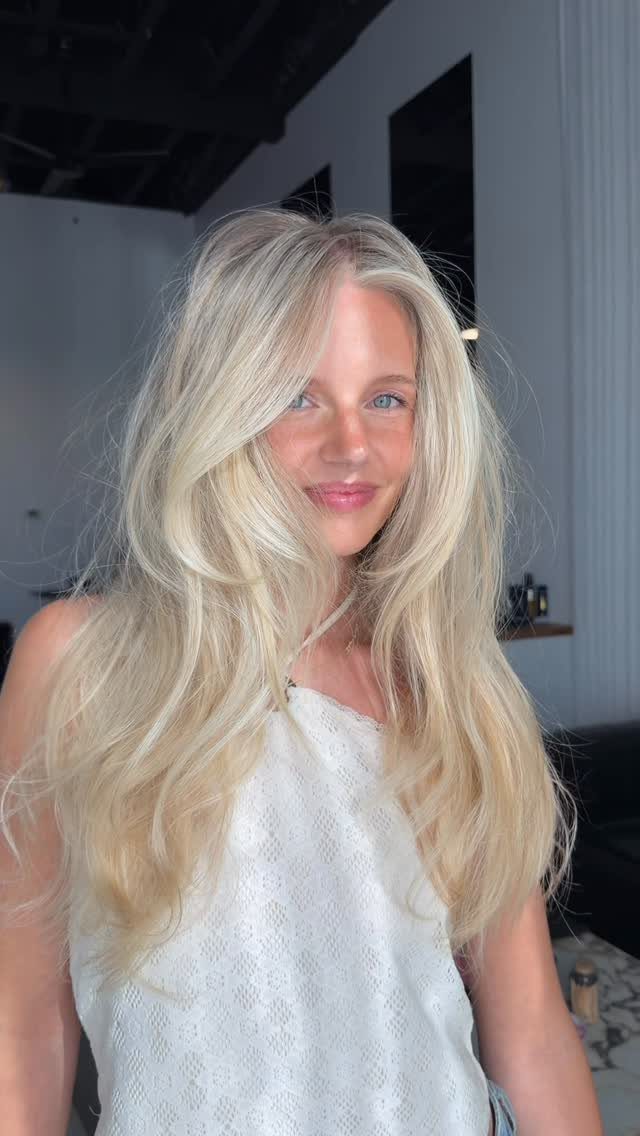 Woman with long blonde hair and bright face-framing pieces