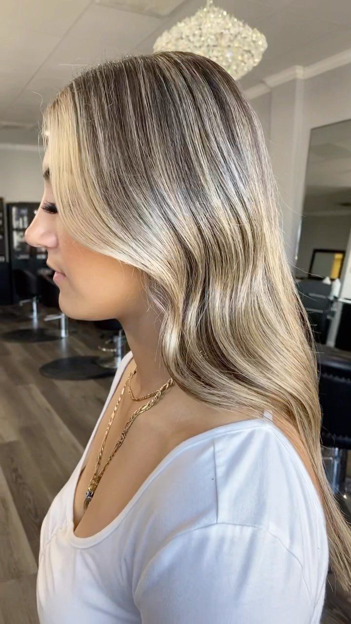 Long straight dark hair with fine blonde babylights in a salon