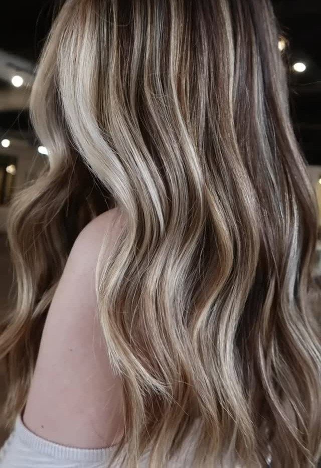 Wavy brunette hair with cool silvery blonde highlights in a salon