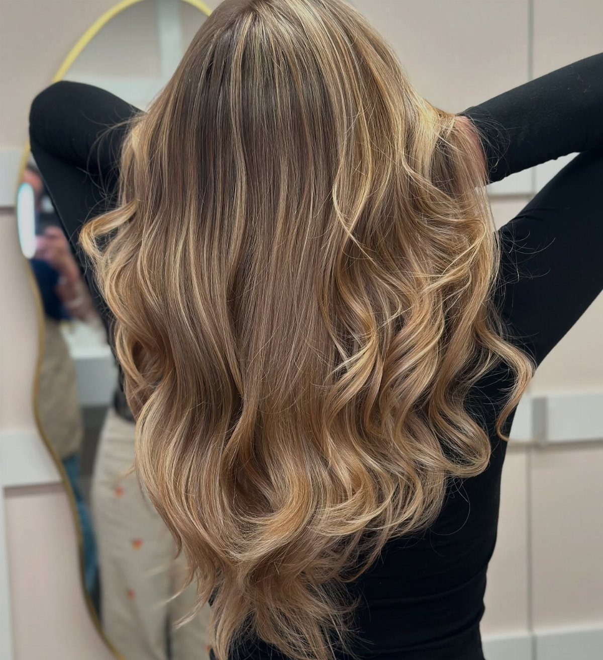 Long wavy hair blends warm and cool blonde highlights through a light brown base