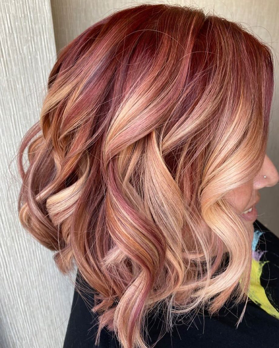 Wavy bob with burgundy roots and copper-blonde and pink highlights
