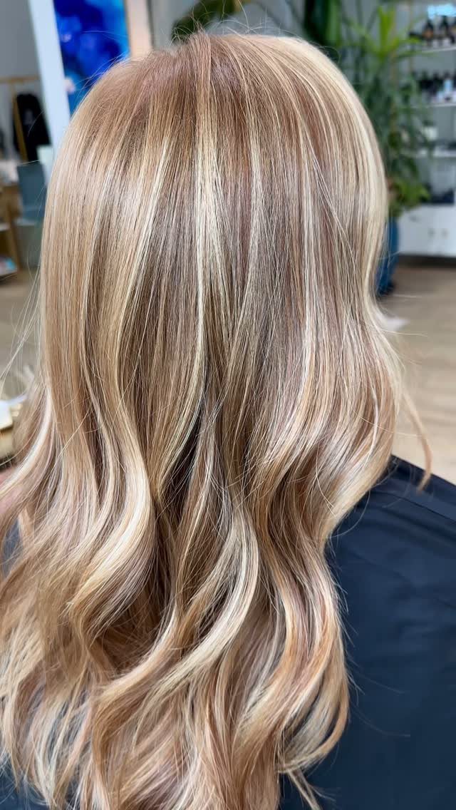 Long wavy golden blonde hair with subtle strawberry-toned streaks
