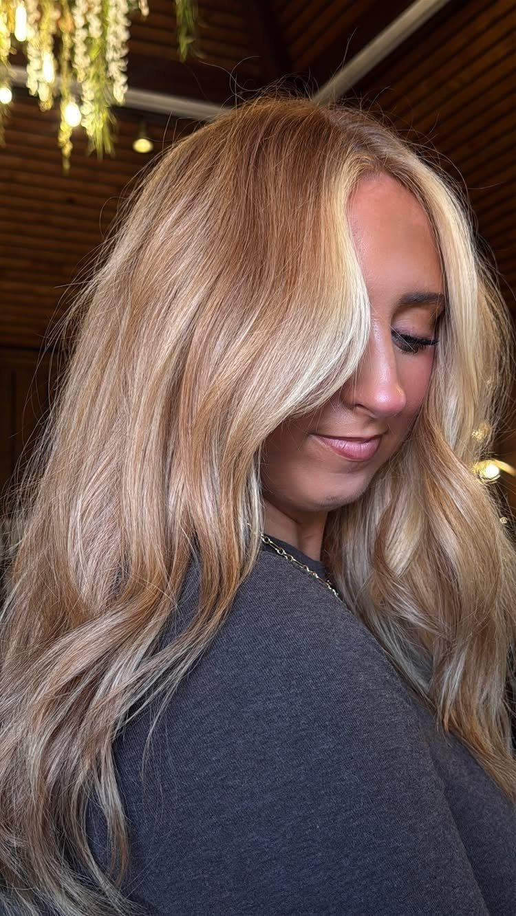 Woman with long lived-in strawberry blonde hair and darker roots
