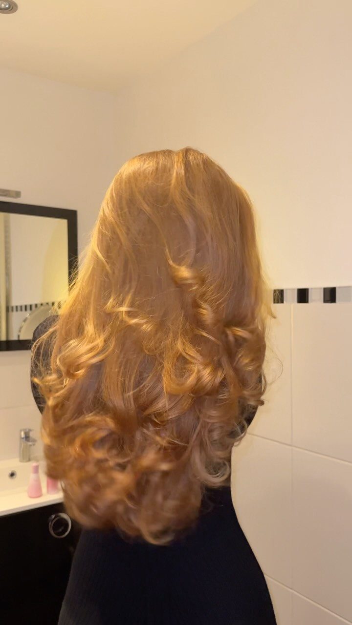 Long wavy peach-blonde hair with warm golden curls shown from behind