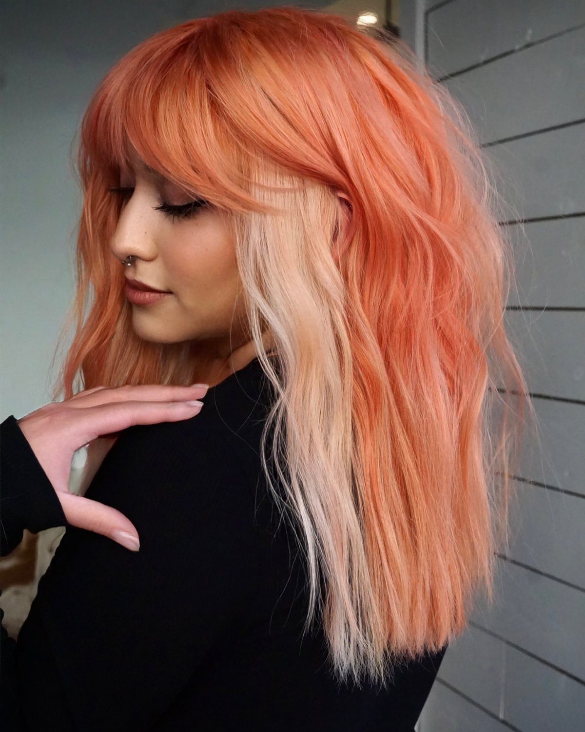 Woman showing peach strawberry blonde hair with pale blonde face-framing strands