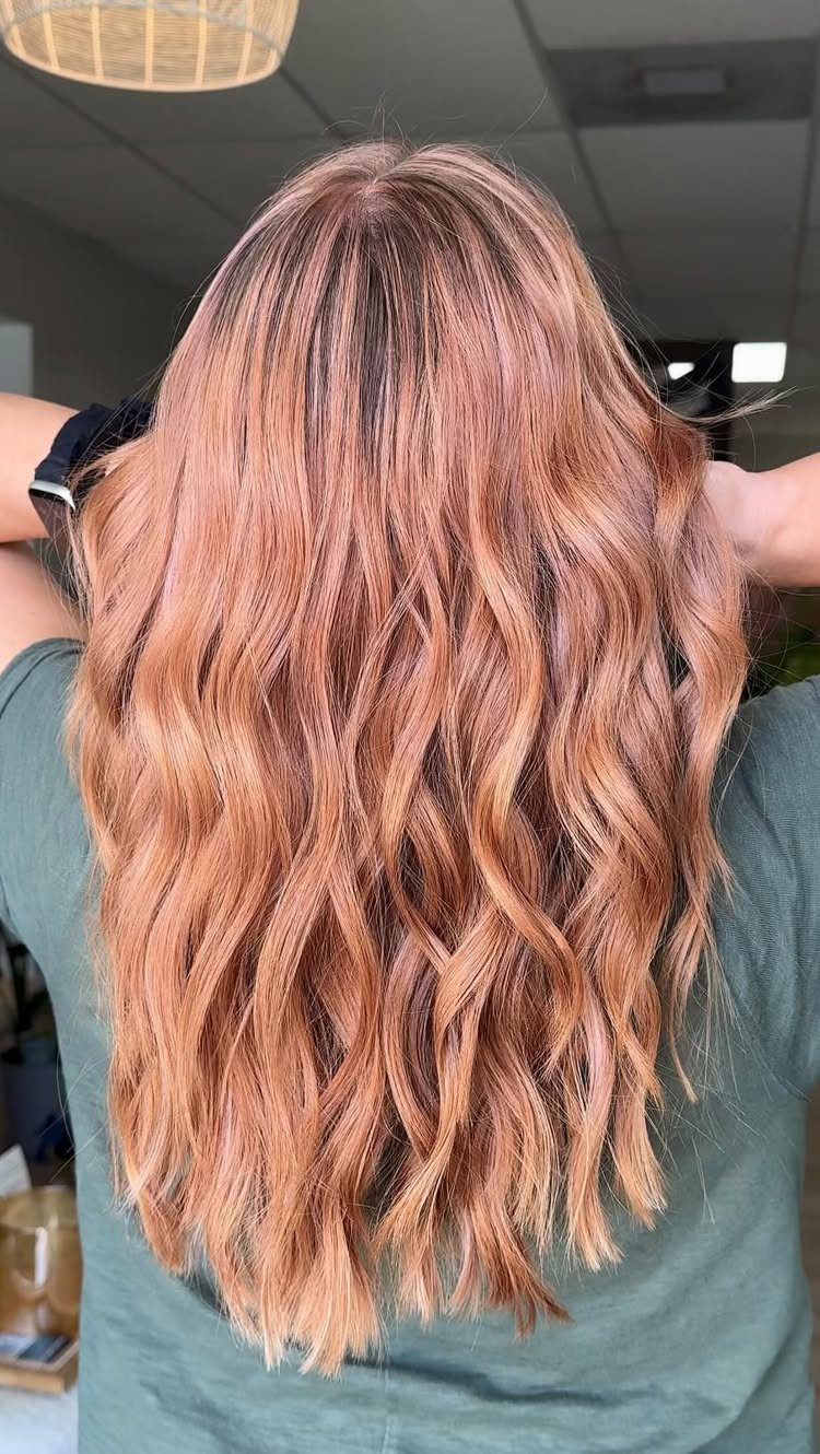 Long rose-gold strawberry blonde waves with rosy pink and golden tones