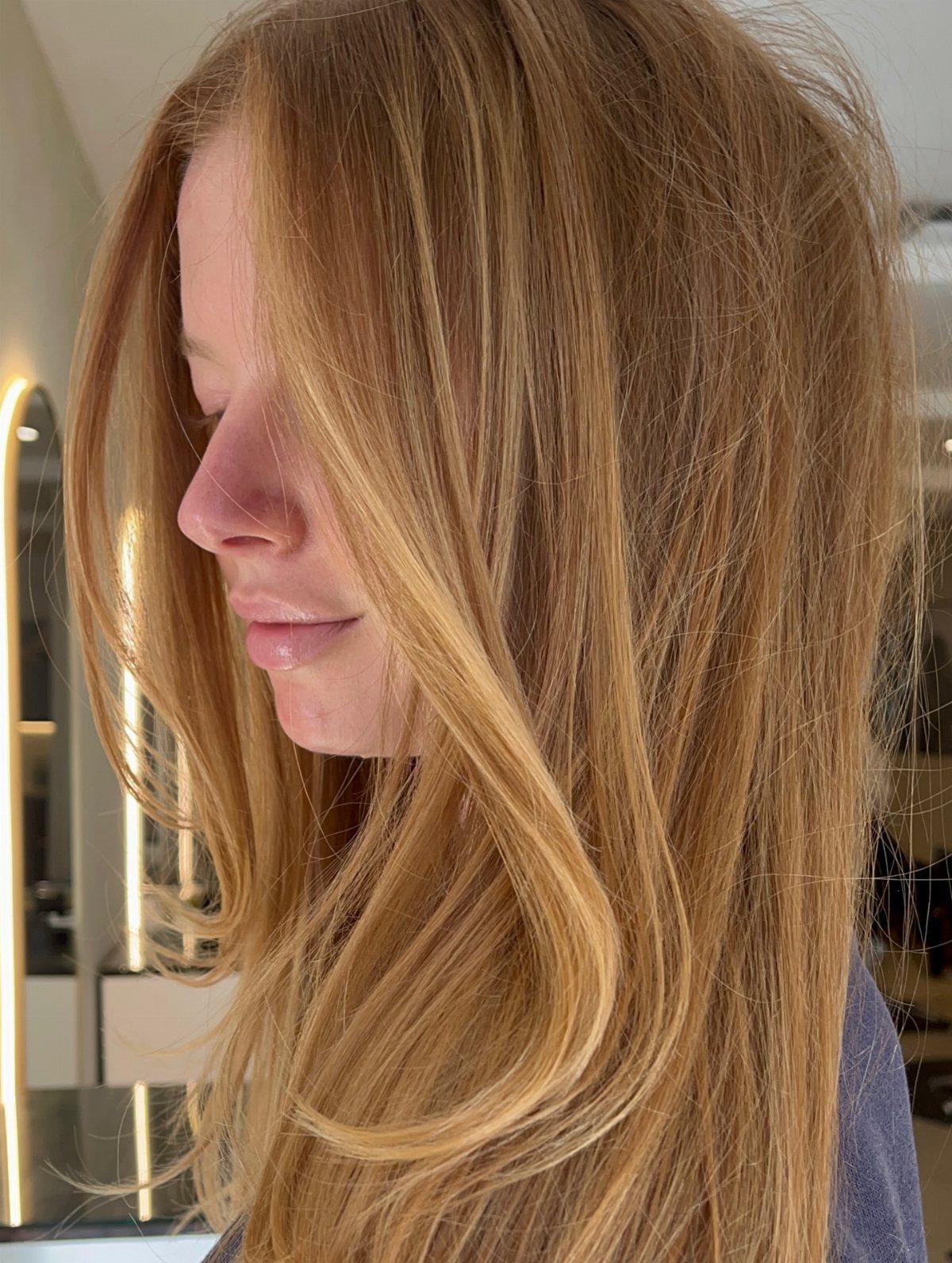 Woman with long strawberry-blonde hair and fine blonde highlights