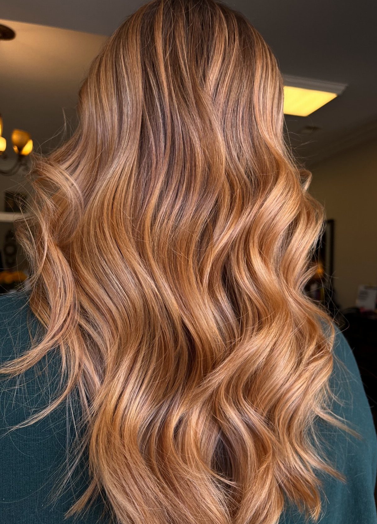 Wavy strawberry blonde hair with pale blonde highlights cascading down