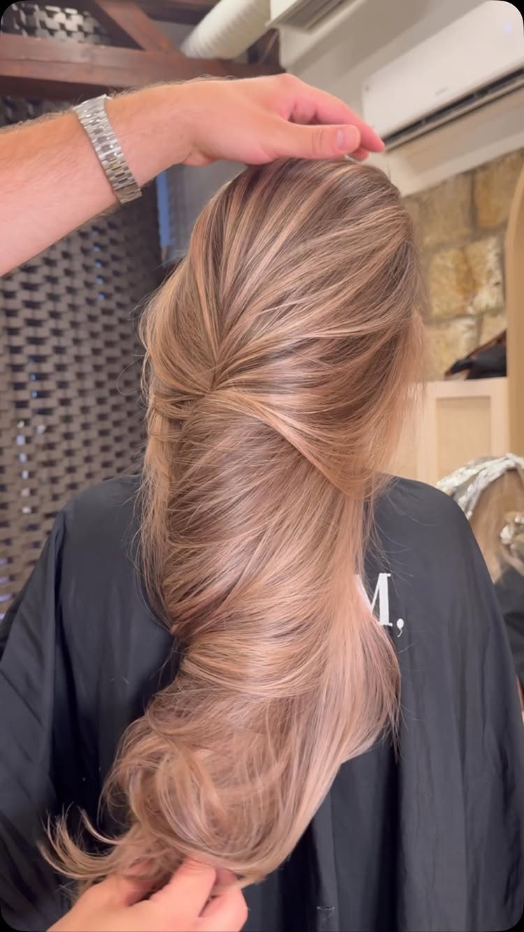 Strawberry-blonde hair with blonde highlights styled into a loose twisted updo