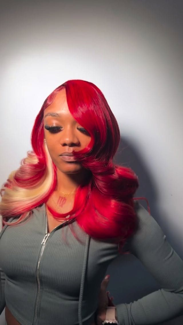 Woman with glossy red curls and a wide blonde highlight through one side
