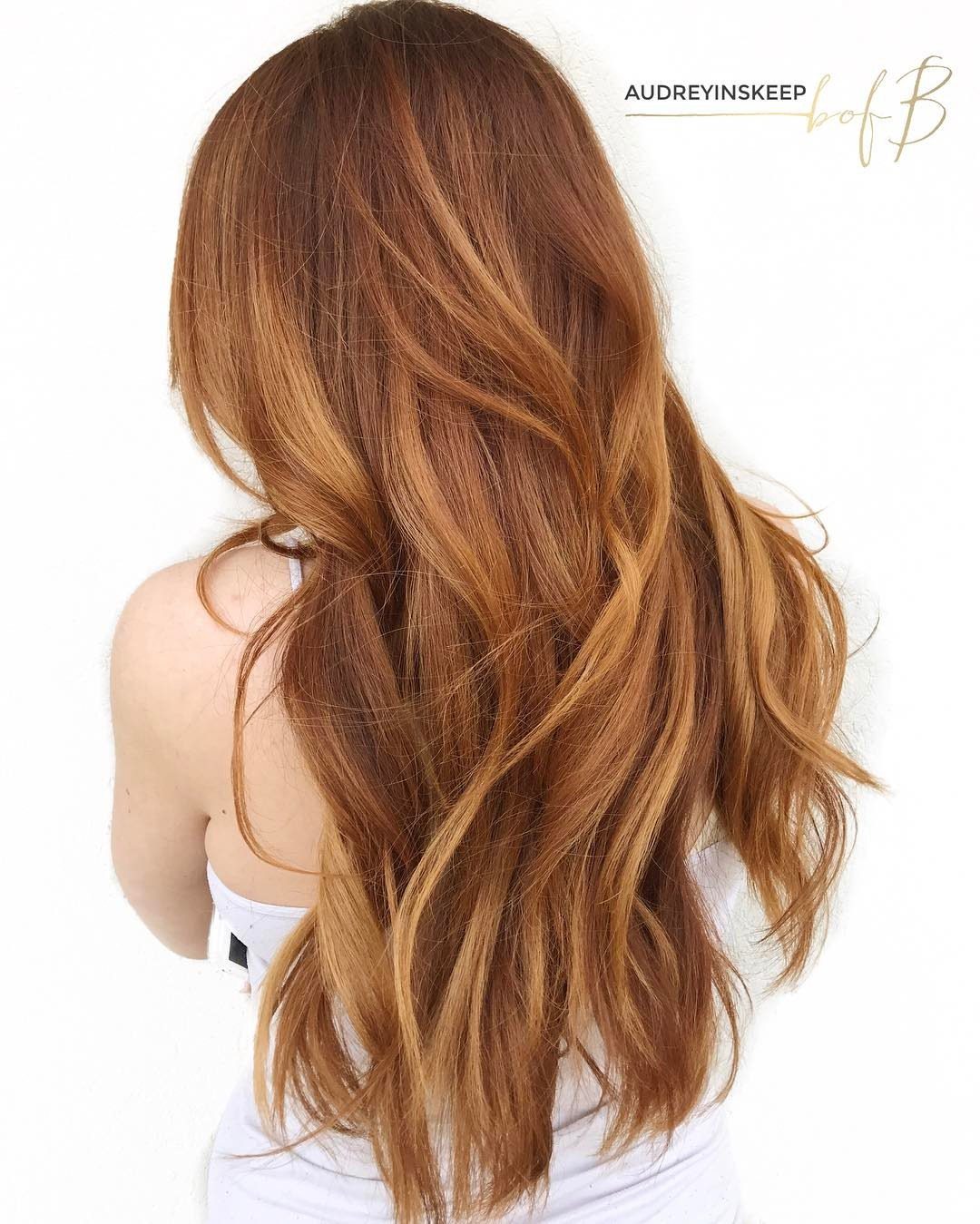 Long wavy copper-red hair fades into lighter blonde ends