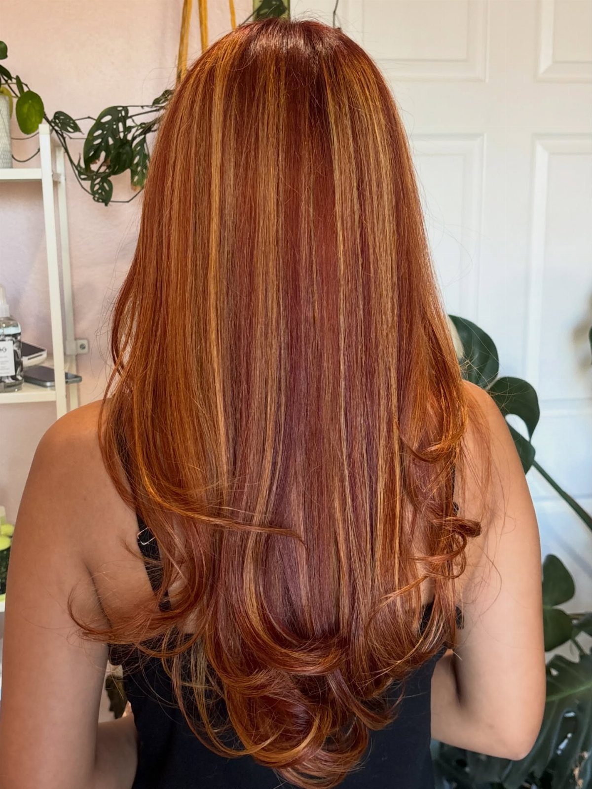 Long auburn hair with blonde highlights styled in loose curls