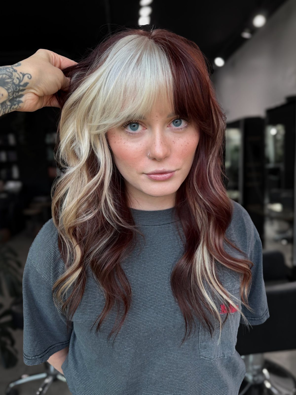 Woman showing long red hair with dramatic blonde highlights and bangs