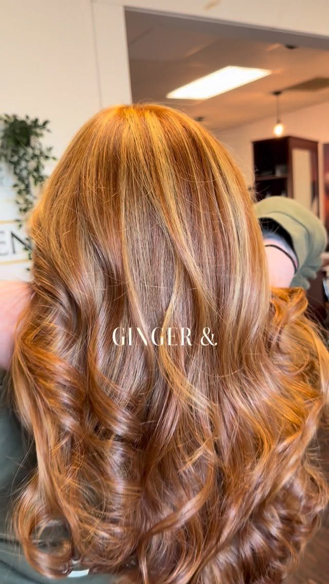 Curled red hair with blonde highlights, shown from behind in a salon
