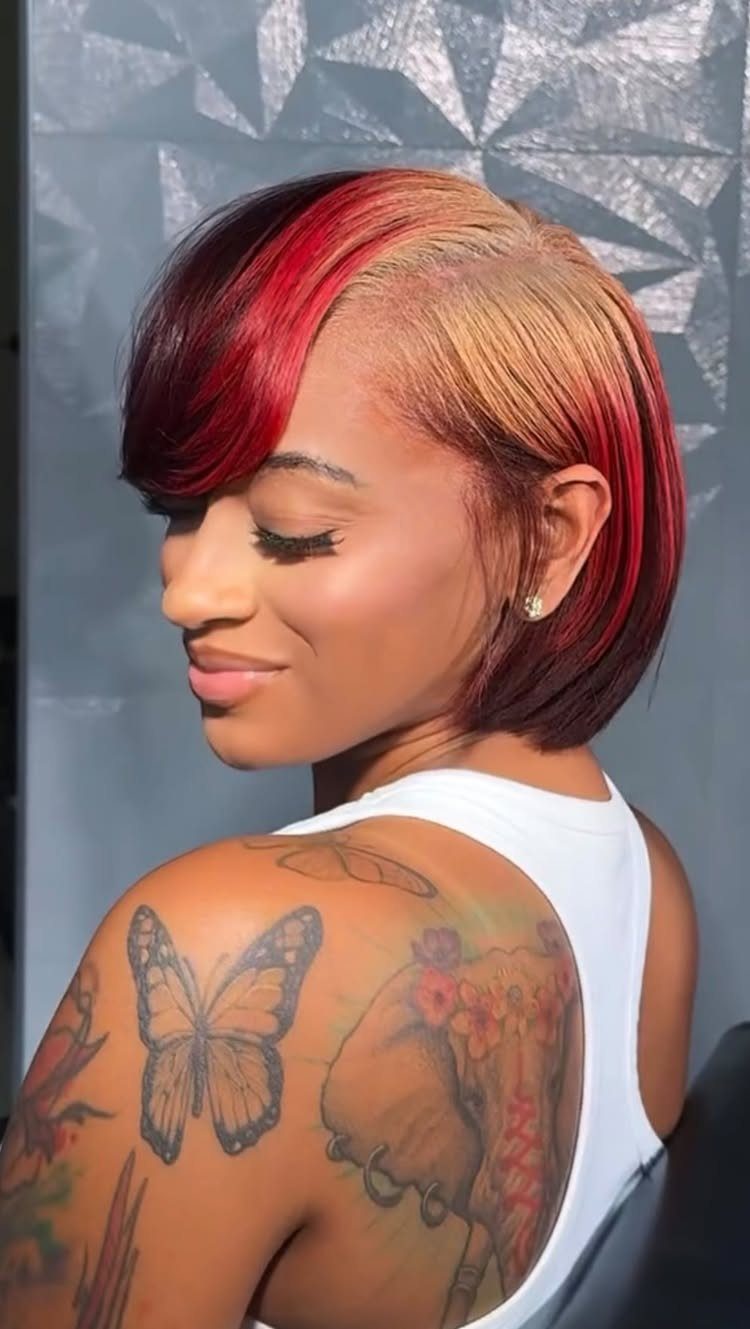 Woman showing a sleek bob with vivid red hair and blonde highlights