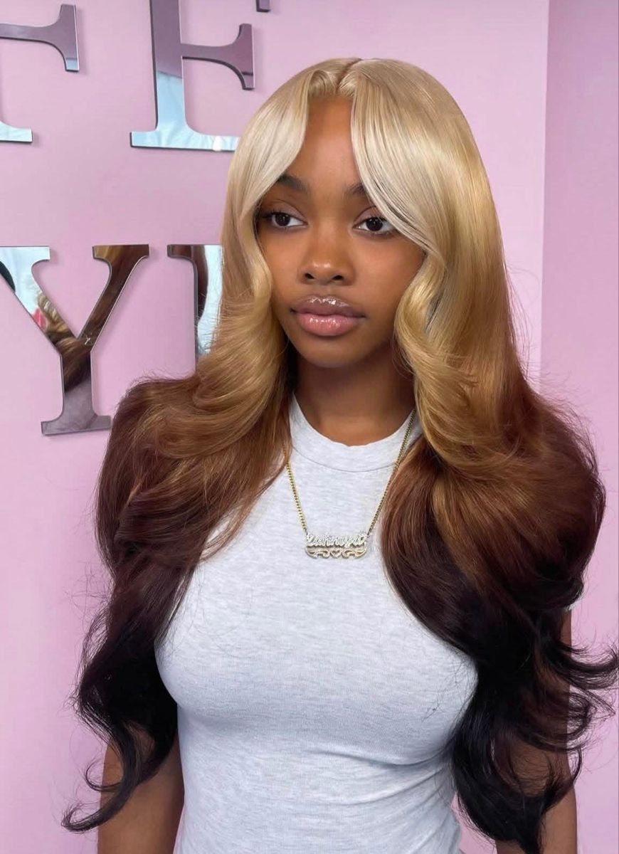 Woman modeling a long wavy blonde wig with lighter face-framing pieces