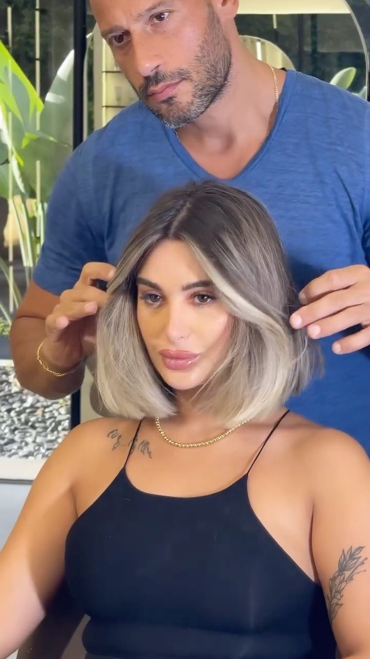 Woman showing a brunette bob with blonde face-framing highlights in a salon