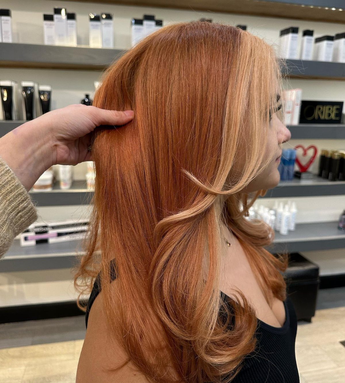 Copper-haired woman with blonde face-framing sections styled in a salon